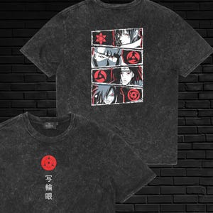 May include: A charcoal grey acid-wash t-shirt featuring a red Sharingan symbol and Japanese text on the front. The back displays a vertical panel of four manga-style character portraits, each paired with a red Sharingan eye graphic in a rectangular frame.