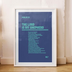 Könnte beinhalten: Ein gerahmter Druck mit dem Text "THE LORD IS MY SHEPHERD" in Weiß und Türkis auf dunkelblauem Hintergrund. Der Druck lehnt an einer weißen Wand auf einem Holzboden, neben einer Holzbank.