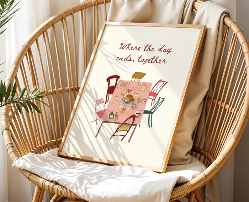 Puede incluir: Una impresi&oacute;n art&iacute;stica enmarcada que presenta una escena de mesa de comedor con sillas, platos y comida. El texto "Where the day ends, together" est&aacute; escrito en borgo&ntilde;a. La impresi&oacute;n se muestra en una silla de mimbre.