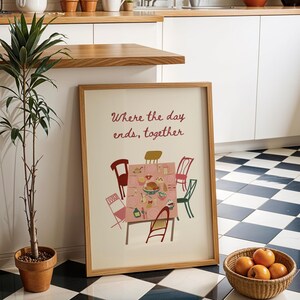 Puede incluir: Una impresi&oacute;n enmarcada con el texto "Where the day ends, together" presenta una ilustraci&oacute;n de mesa con sillas. Una planta en maceta y una cesta de naranjas est&aacute;n cerca. El suelo tiene un patr&oacute;n de cuadros blancos y negros.