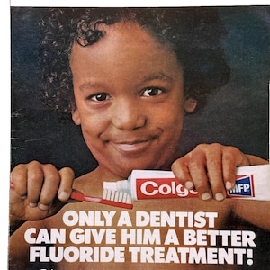 May include: Vintage advertisement featuring a smiling child holding a tube of Colgate toothpaste and a red toothbrush. The text reads, "ONLY A DENTIST CAN GIVE HIM A BETTER FLUORIDE TREATMENT!"