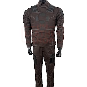 May include: A brown tactical jumpsuit with a high collar, featuring reinforced panels on the chest and shoulders. The outfit includes matching pants with pockets and black gloves. The overall design suggests a military or tactical theme.