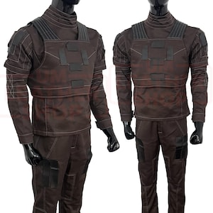 May include: Two brown tactical outfits displayed on mannequins. Each outfit includes a long-sleeved shirt, pants, and a chest rig with black accents. The outfits have a high collar and multiple pockets.