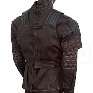 May include: A brown jacket with black shoulder accents and white stitching. The jacket has a high collar and a fitted waist. The sleeves feature geometric stitching patterns. The back view of the jacket is shown.