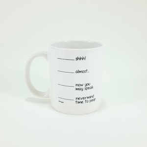 May include: White ceramic mug with a curved handle. The mug features black text that reads "shhh!", "almost...", "now you may speak", and "nevermind time to poop". The mug has a humorous design.