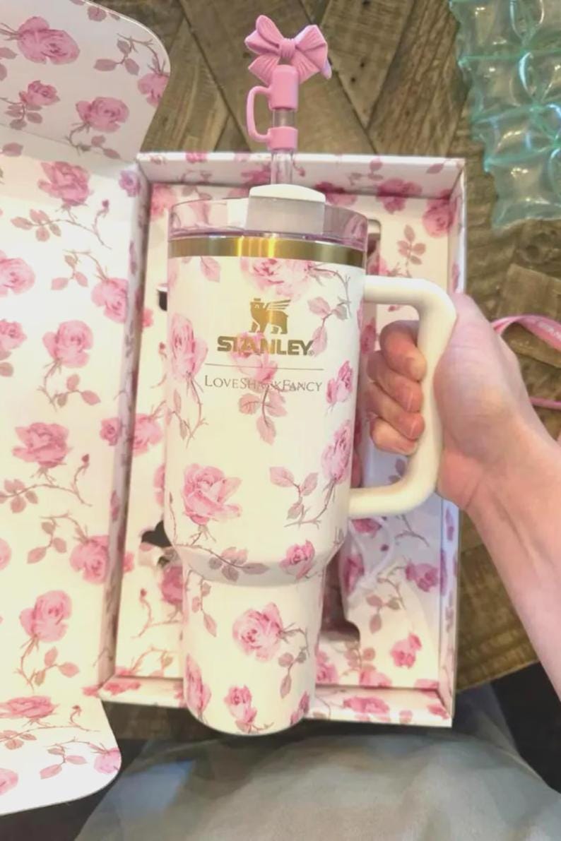 May include: A white ceramic mug with a black handle and the text "But First, Coffee" in a black, handwritten-style font. The mug is on a white surface.