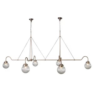 May include: A bronze-colored, multi-light pendant lamp with six globe-shaped, ribbed glass shades. The fixture has a linear design with curved arms and is suspended by chains and wires, suitable for a kitchen island or dining area.