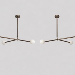 Könnte beinhalten: Zwei moderne Kronleuchter mit Bronze-Finish. Jede Leuchte hat einen zentralen Stiel und horizontale Arme mit weißen Kugellampen an den Enden. Das Design ist minimalistisch und elegant, passend für verschiedene Einrichtungsstile.