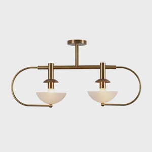May include: A brass-toned ceiling light fixture with two frosted glass bowl-shaped shades. The fixture has a horizontal bar with curved arms and a central vertical support for mounting. The light bulbs are visible inside the shades.