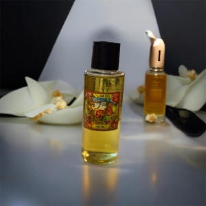 May include: Two glass bottles of liquid with black and gold caps. The front bottle has a colourful label with the text "GAN DOKI". The liquid is yellow. The background is white and black with white flower-like decorations.