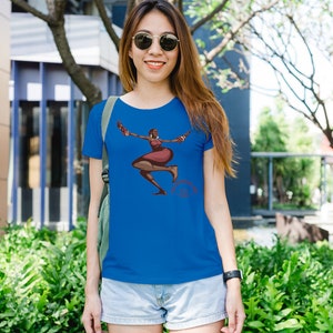 May include: A royal blue t-shirt featuring a graphic of a dancing figure in shades of brown and red. The figure is depicted with arms outstretched and legs in motion. The t-shirt is made of a soft material.