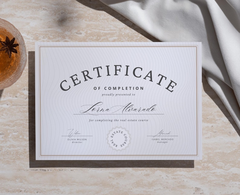 Puede incluir: Un certificado blanco con borde dorado, con el texto "CERTIFICATE OF COMPLETION" y el nombre "Lorna Alvarado". El certificado incluye firmas y un sello del curso de bienes ra&iacute;ces. El fondo es de color beige claro.