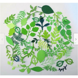 May include: A collection of green paper leaves and branches, cut in various shapes and sizes. The leaves are arranged in a circle on a white background.