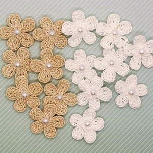May include: A collection of crocheted flower embellishments in white and beige with pearl centers.