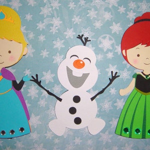 K&ouml;nnte beinhalten: Drei Papier-Ausschnitte von Figuren aus dem Film Frozen. Die Figuren sind Elsa, Anna und Olaf. Elsa tr&auml;gt ein blaues und violettes Kleid mit einer Krone. Anna tr&auml;gt ein gr&uuml;nes Kleid. Olaf ist ein Schneemann mit einer Karottennase und St&ouml;cken als Armen.