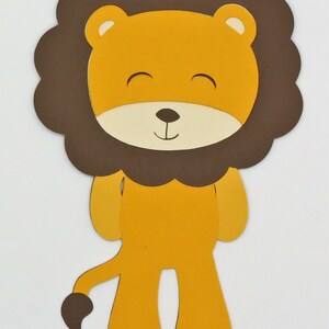 Puede incluir: Un recorte de papel marr&oacute;n y amarillo de un le&oacute;n con una melena marr&oacute;n. El le&oacute;n tiene una cara sonriente con los ojos cerrados y una peque&ntilde;a nariz negra.