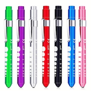 May include: Seven colorful penlights in green, purple, silver, red, black, blue, and pink. Each penlight has a silver clip, a series of white dots, and the text "9mm CE" printed on the side. The penlights are arranged vertically.