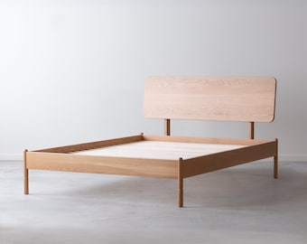 May include: A wooden bed frame with a headboard and a slatted base. The frame is made of light wood and has a simple, modern design.