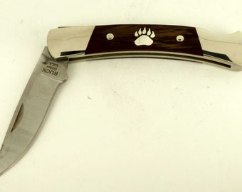 Buck folding knife with sterling silver bear paw inlay