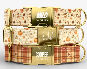 May include: Three pet collars with gold-tone metal buckles engraved with names and phone numbers. The top collar features a coffee and pinecone pattern, the middle has a pumpkin and leaf print, and the bottom displays a brown plaid pattern.