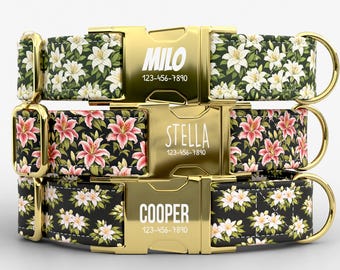 May include: Three personalized dog collars with floral patterns. The top collar has white flowers on a dark green background, the middle has pink flowers, and the bottom has white flowers on black. Each collar has a gold buckle with a name and phone number.