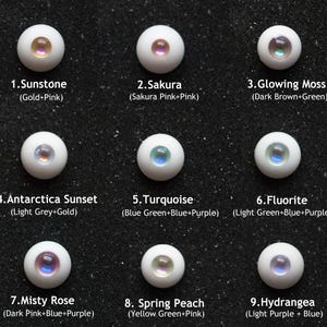 May include: Nine doll eyes in various colors, including Sunstone (Gold+Pink), Sakura (Sakura Pink+Pink), and Glowing Moss (Dark Brown+Green). Each eye has a white base with a colored iris. The text labels each eye with a number and color description.