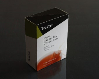 May include: A box of TeaVert Organic Green Tea Collection with a black, green, and white design. The box features the text "TeaVert" in a white font and "Organic Green Tea Collection" in a black font. The box also lists the tea flavors: Jasmine, Moroccan Mint, and Kukicha.