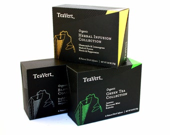 May include: Three black boxes of organic tea with gold lettering. The top box says "Organic Herbal Infusion Collection" with the flavors "Chamomile & Lemongrass, Madrid Fusion, Nettle & Peppermint". The middle box says "Organic Black Collection" with the flavors "English Breakfast, Early Grey, Darjeeling". The bottom box says "Organic Green Tea Collection" with the flavors "Jasmine, Moroccan Mint, Kukicha".