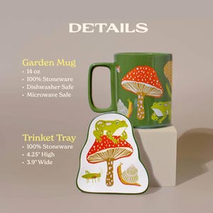 Close-up of matching frog and mushroom ceramic mug and trinket tray showing intricate red toadstool and frog illustrations. The stoneware pieces are microwave and dishwasher safe bringing a touch of nature whimsy to cozy kitchen moments or desk decor.
