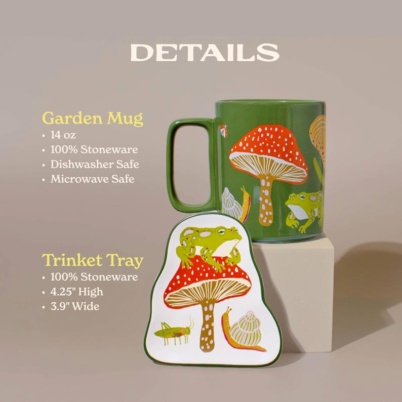 Close-up of matching frog and mushroom ceramic mug and trinket tray showing intricate red toadstool and frog illustrations. The stoneware pieces are microwave and dishwasher safe bringing a touch of nature whimsy to cozy kitchen moments or desk decor.