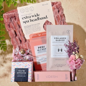 May include: A gift set with a pink spa headband, collagen gloves, hand balm, and a pedicure kit. The set includes a box of "You're Awesome" cards and a small bouquet of dried flowers. The packaging is mostly pink and white.