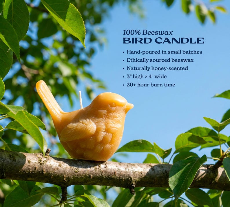 a hand-poured small batch of ethically sourced beeswax bird candle. It is naturally honey-scented, 3 high x 4 wide, and has a 20-hour burn time. The candle is perched on a branch, surrounded by green leaves, creating a serene and natural setting.