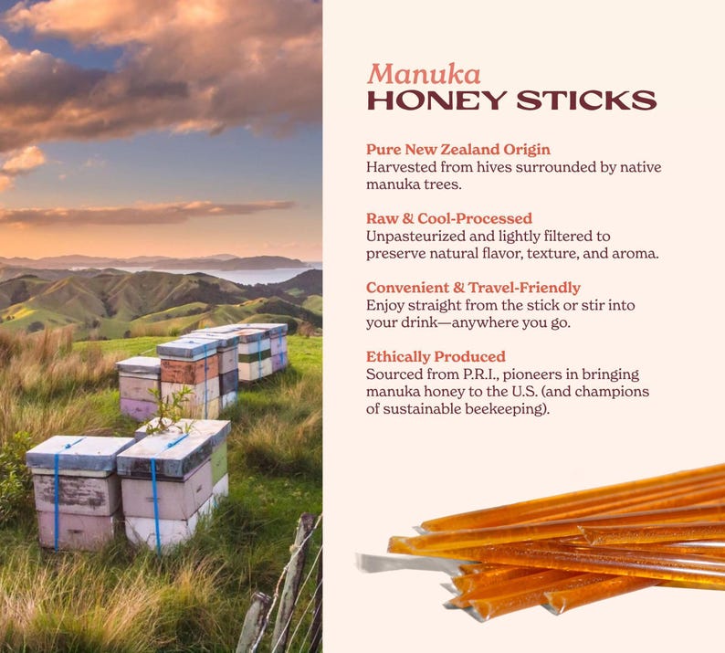 Golden honey sticks photographed beside a scenic New Zealand landscape with beehives under a sunset sky. This pure raw manuka honey is sustainably harvested and ideal for stirring into jasmine green tea or drizzling over breakfast for a touch of natural sweetness.