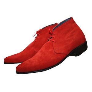 Puede incluir: Un par de botines de ante rojo vibrante con punta afilada, cordones rojos a juego y una suela negra sólida. El forro interior de los botines es de un color azul que contrasta. Estos botines presentan un diseño elegante y de perfil bajo.