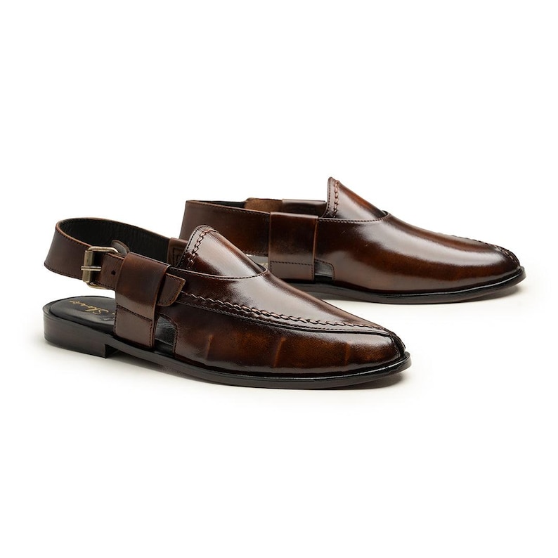 May include: A pair of brown leather sandals with a pointed toe and a buckle closure. The sandals have a glossy finish and a stitched design along the edges. The open-toe design and slingback strap offer a stylish and comfortable fit.