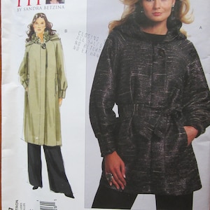 May include: Vogue Patterns V1097 sewing pattern. The pattern features a long coat with a hood and a tie waist. The cover shows a woman wearing the coat. The pattern includes all sizes. The text "Today's Fit" is visible.