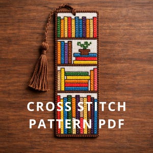 May include: A cross-stitch bookmark featuring a bookshelf design with colorful books and a small potted plant. The bookmark has a brown tassel and the text "CROSS STITCH PATTERN PDF" in white.
