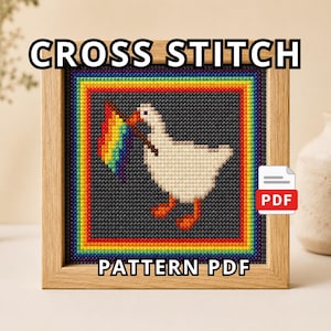 May include: A cross stitch pattern PDF featuring a white goose with orange feet and beak holding a rainbow flag. The design is set against a dark gray background, framed by a vibrant rainbow border, with the text CROSS STITCH PATTERN PDF.