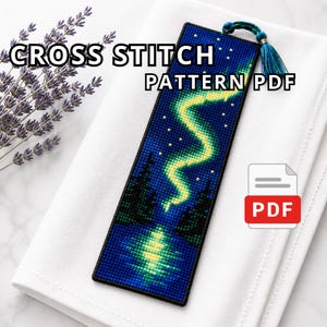 Pode incluir: Um PDF de padrão de ponto cruz com um design de marcador. O marcador retrata uma cena da aurora boreal em tons de azul e verde. O texto "CROSS STITCH PATTERN PDF" é exibido na imagem.