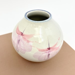 Puede incluir: Un juego de tres tazas de cerámica con un acabado mate moteado. Las tazas son de color crema, gris claro y gris oscuro. Cada taza tiene un diseño simple y minimalista.