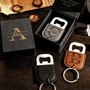 May include: Three personalized bottle opener keychains in black, gray, and brown leather-like material, each featuring a metal opener and a split ring. One is inside a black gift box with the name Alex, while others are labeled Chase and Brian.