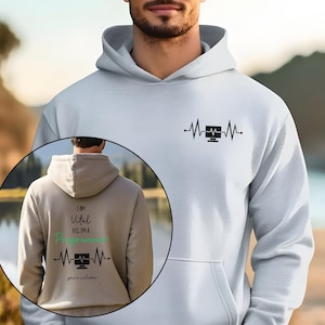 Może przedstawiać: Biała bluza z kapturem z czarną grafiką monitora komputera i wzorem linii bicia serca. Tył bluzy z kapturem na zdjęciu ma napis "I AM Vital YES I'M A Programmer" w kolorze czarnym i zielonym.