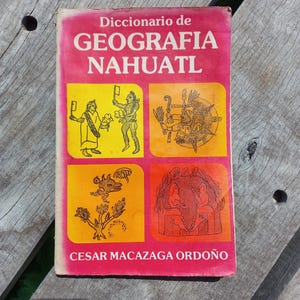 May include: A vintage book titled "Diccionario de Geografia Nahuatl" with a pink cover and illustrations. The cover features four colorful panels with drawings and the author's name, Cesar Macazaga Ordoño, at the bottom.