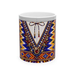 May include: A white ceramic mug featuring a vibrant graphic print of a blue, yellow, and red garment with intricate, colorful beaded and gemstone-like patterns. The design includes a V-neckline with a decorative tie and detailed jewel embellishments.