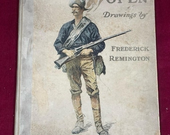 Könnte beinhalten: Antiker Buchumschlag mit dem Titel "DONE IN THE OPEN" und einer Illustration eines Mannes in Militäruniform mit einem Gewehr. Der Umschlag zeigt auch "Drawings by Frederick Remington" und das Jahr 1902.