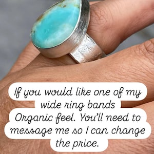 May include: A silver ring with a large, teardrop-shaped turquoise stone. The ring has a wide band with a textured finish. The text on the image says, "If you would like one of my wide ring bands Organic feel."