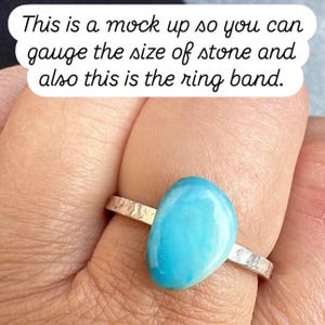 May include: A silver ring with a hammered band and a large, oval, light blue stone. The text on the image reads, "This is a mock up so you can gauge the size of stone and also this is the ring band."