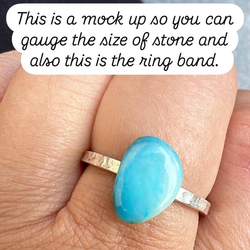 May include: A silver ring with a hammered band and a large, oval, light blue stone. The text on the image reads, "This is a mock up so you can gauge the size of stone and also this is the ring band."