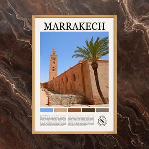 May include: A framed print featuring the word "MARRAKECH" above a photograph of a building with a tall minaret and palm tree. The building is made of reddish-brown brick, set against a blue sky. The print includes a color palette and text.
