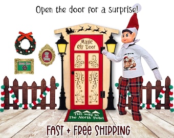 May include: A Christmas-themed scene featuring a wooden door with the text "Magic Elf Door". An elf stands beside the door, wearing a red and white hat and plaid pants. Decorative elements include a wreath, a framed sign, and a garland.